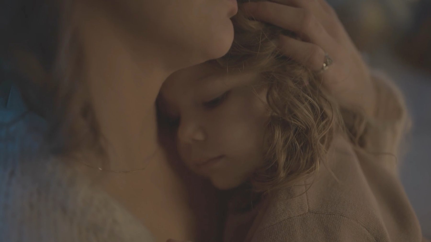 Filmstill: Eine Mutter hält ihr schlafendes Kind im Arm